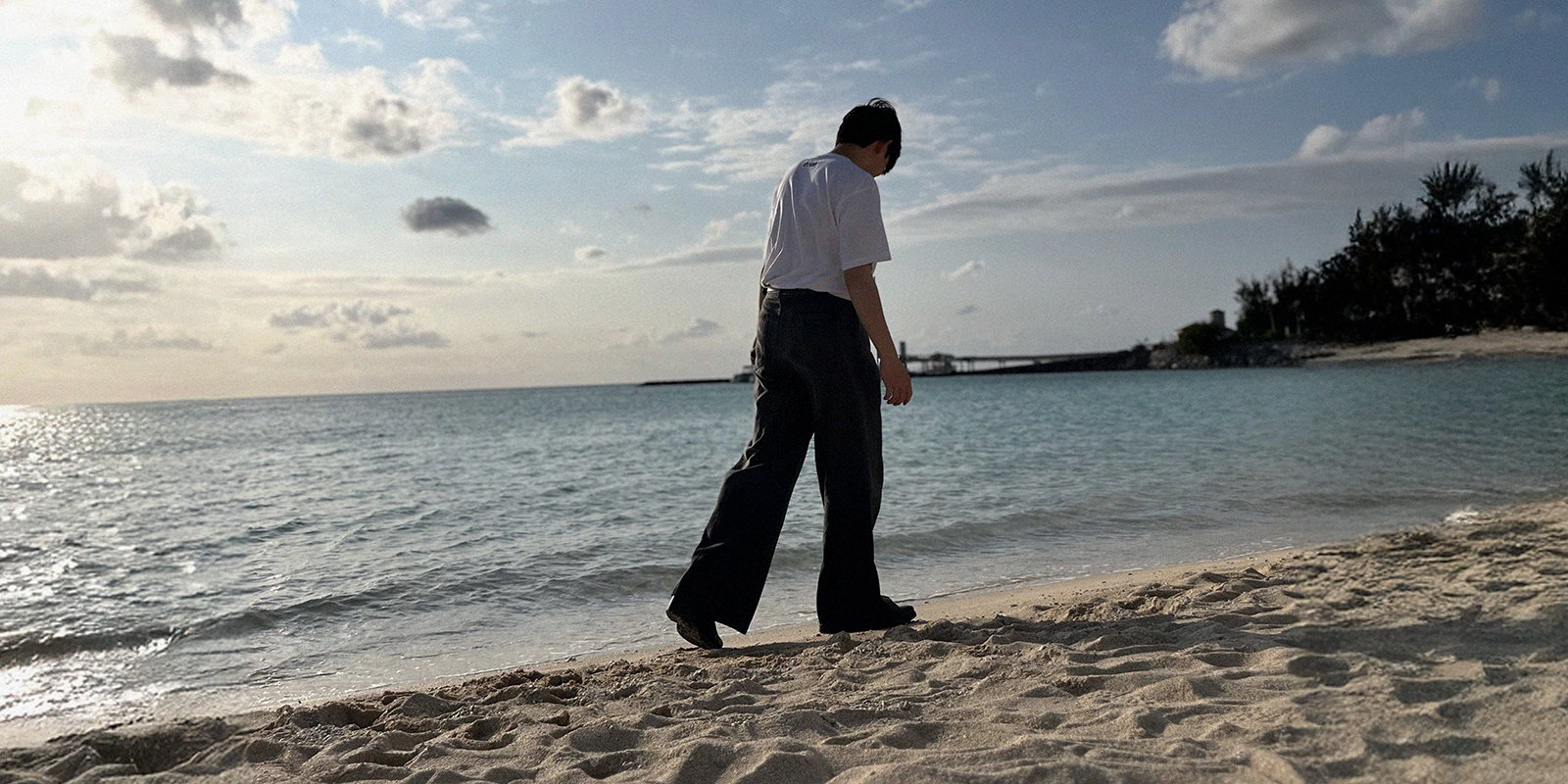 海辺を歩く後ろ姿